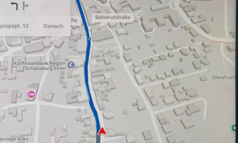 Close-up of a car's navigation screen showing a 3D map with a blue route.