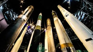 A collection of large rockets displayed vertically in a museum setting.