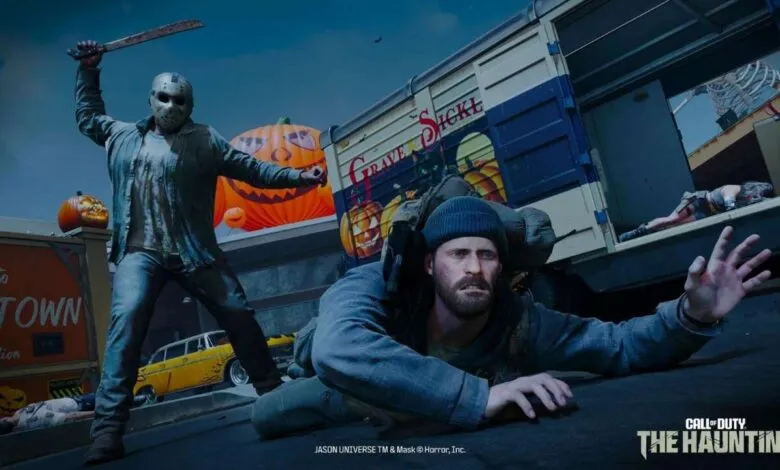 Jason Voorhees attacks a man in a blue beanie, with a truck and pumpkins in the background.