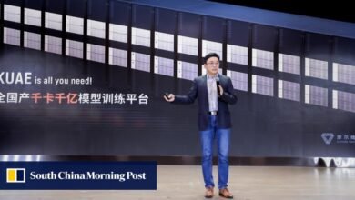 Man presenting in front of a large server rack display with Chinese text and KUAE logo.