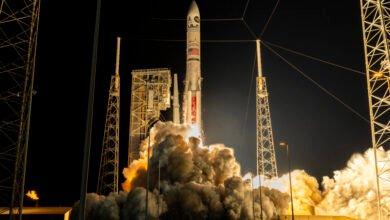 A rocket launches at night, spewing massive amounts of smoke and fire.