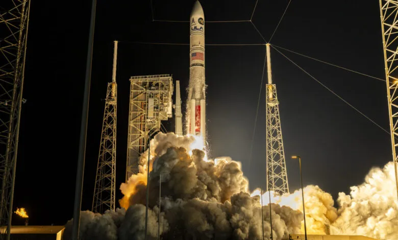 A rocket launches at night, spewing massive amounts of smoke and fire.