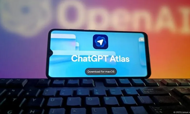 Smartphone displaying ChatGPT Atlas app with download button for macOS, placed on a keyboard.