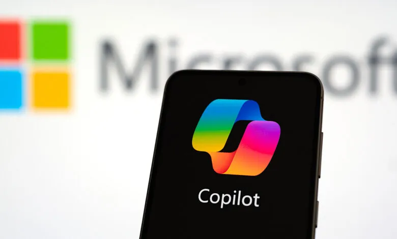Smartphone displaying the Copilot AI logo with the Microsoft logo blurred in the background.
