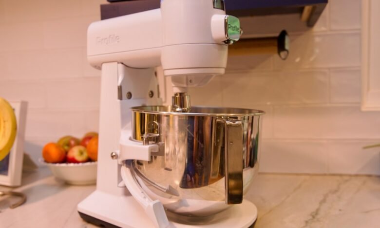 White stand mixer with a stainless steel bowl on a kitchen counter.