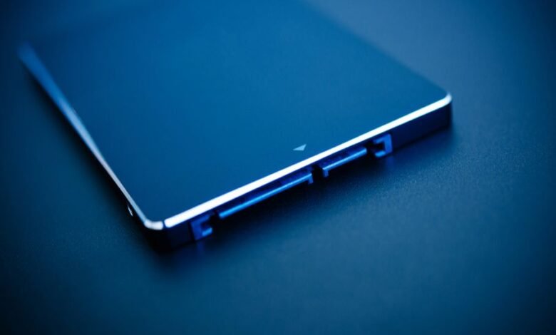 Close-up of a sleek, dark blue SSD with blue illuminated SATA connectors.