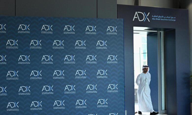Man in traditional Emirati attire walks past ADX Abu Dhabi Securities Exchange branding.