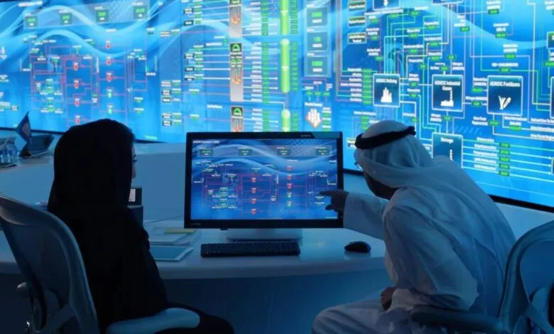 Two people in traditional Middle Eastern attire review complex data on large screens.