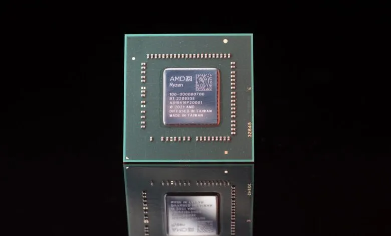 Close-up of an AMD Ryzen processor chip with its reflection on a black surface.