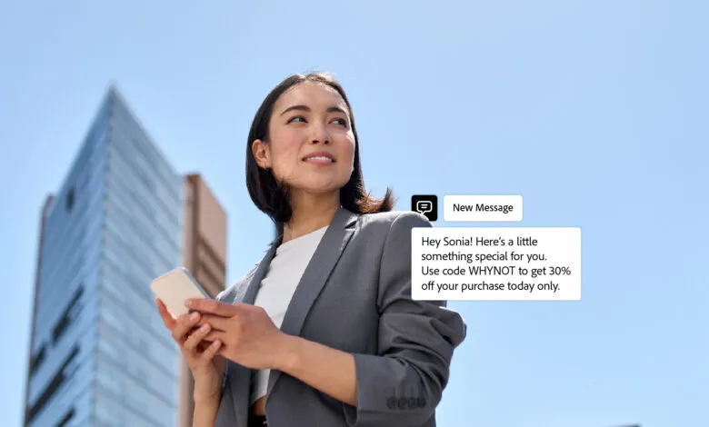 Woman in business attire holding a smartphone, looking up with a smile.