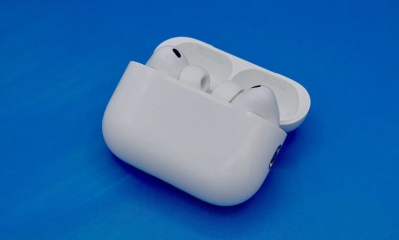 White Apple AirPods Pro earbuds in their charging case on a blue background.