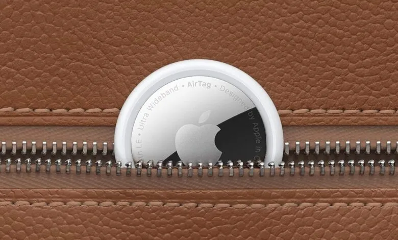 Apple AirTag with Apple logo partially visible, nestled in a brown leather case with a zipper.