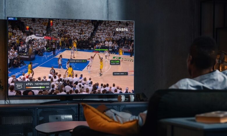 Man watching a basketball game on TV with advanced AI stats displayed.