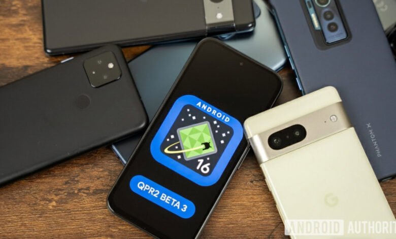 Several smartphones are arranged on a wooden surface, with one displaying the Android 16 QPR2 Beta 3 logo.