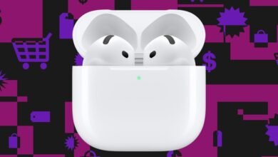 White Apple AirPods Pro earbuds in their charging case with a green indicator light.