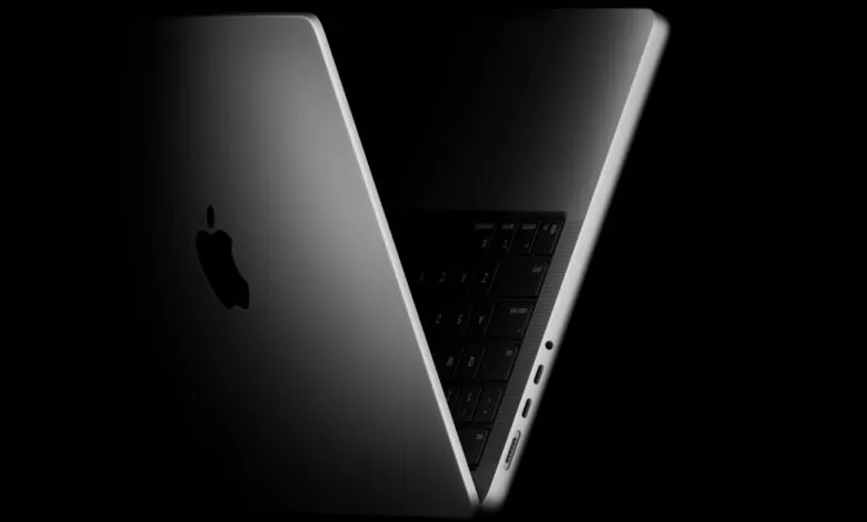 Close-up of a silver Apple MacBook Pro laptop with the lid partially open, showing the keyboard and Apple logo.