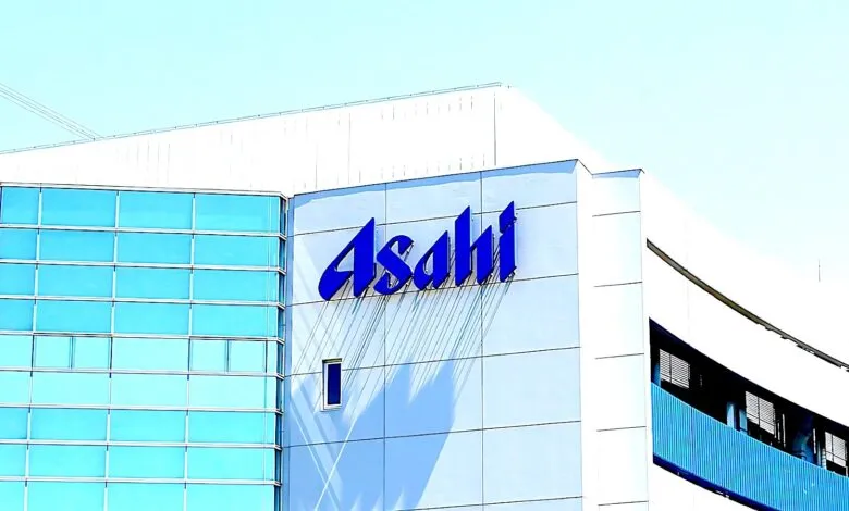 The blue Asahi logo is prominently displayed on the side of a modern white building with blue glass windows.