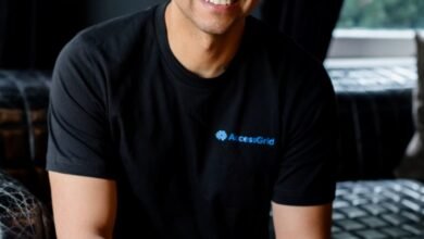 Man wearing a black t-shirt with AccessGrid logo and a baseball cap, smiling.