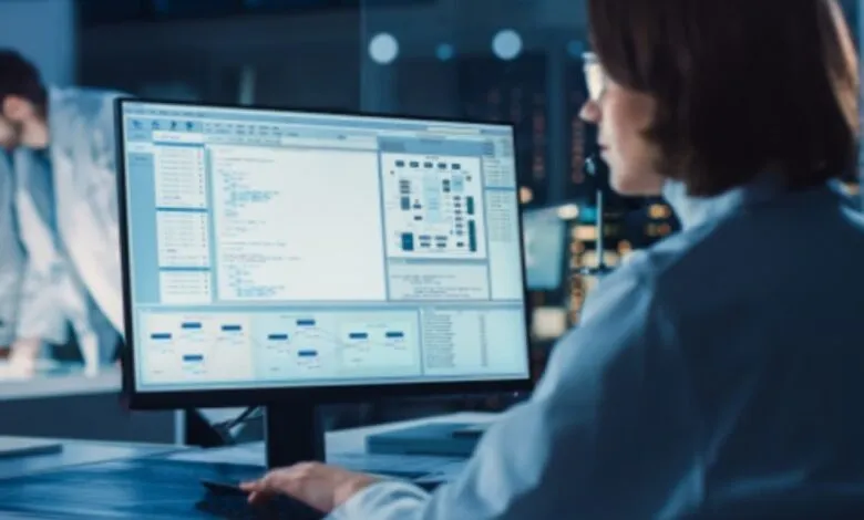 Scientist working on complex data on a computer screen in a lab.