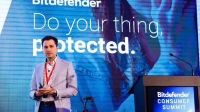 Man in a suit presenting on stage with Bitdefender branding behind him.