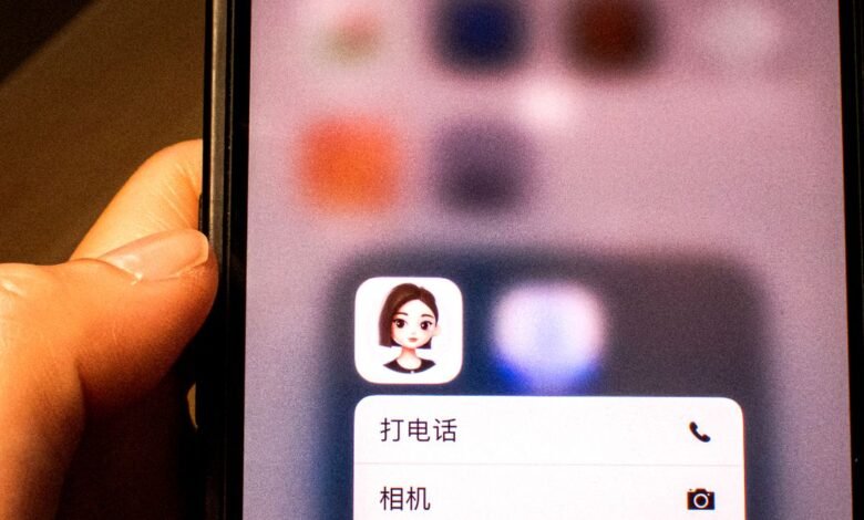 Close-up of a hand holding a smartphone displaying app icons and menu options.