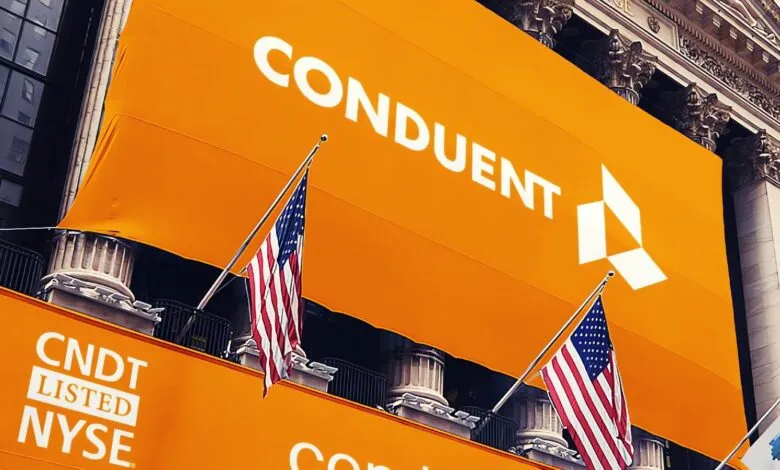 Conduent logo and ticker symbol CNDT listed on NYSE, with American flags flying.
