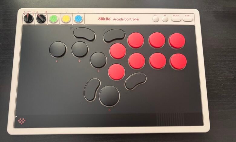 8BitDo Arcade Controller with red and black buttons on a dark surface.