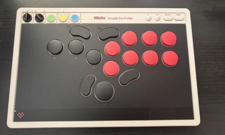 8BitDo Arcade Controller with red and black buttons on a dark surface.
