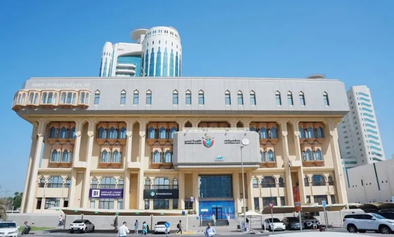 The Dubai Land Department building with its distinctive architecture under a clear blue sky.