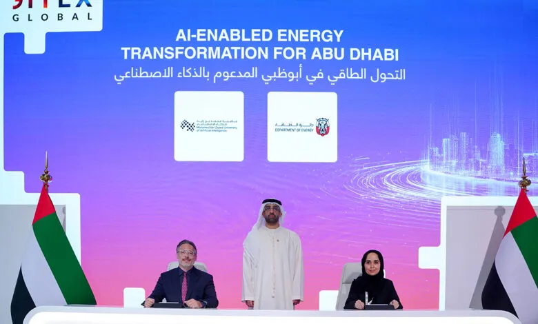 Three individuals seated at a table with the GITEX GLOBAL logo and AI-enabled energy transformation text on a screen behind them.