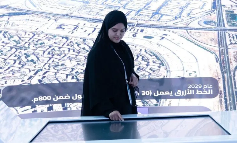 Woman in hijab interacting with a large interactive map display.