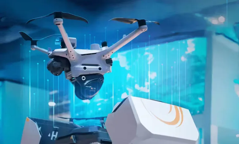A white drone with a camera hovers above futuristic equipment with blue digital lines.