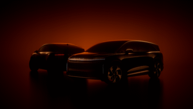 Two dark Lucid electric vehicles silhouetted against a warm orange background.