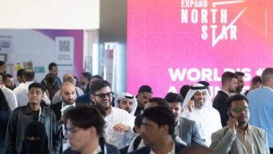 Diverse group of professionals attending the Expand North Star event, with a large pink banner in the background.