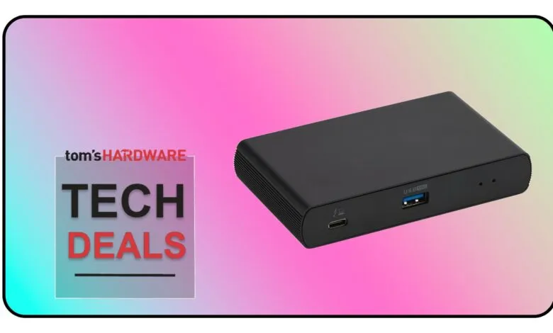 Black USB-C hub with multiple ports on a gradient background.