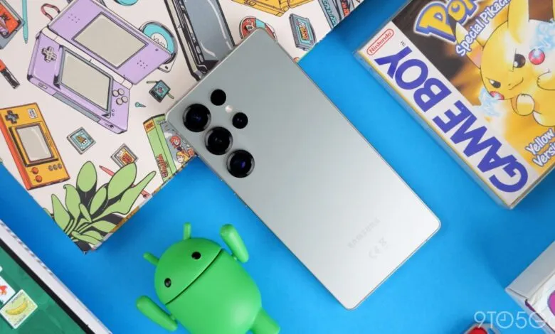 Silver Samsung Galaxy S25 Ultra phone with multiple cameras next to retro gaming items.