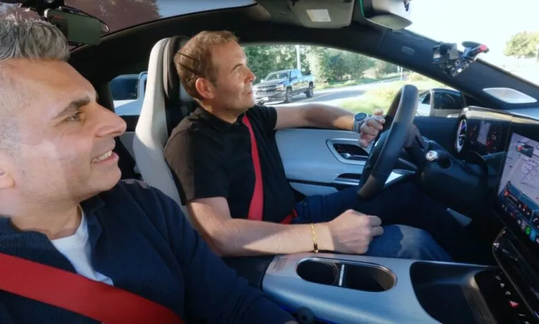 Two men in a car, one driving, with a dashboard display showing navigation.