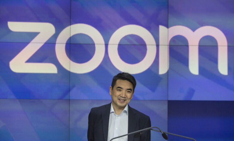 Eric Yuan, founder of Zoom, smiles in front of the Zoom logo at Nasdaq.