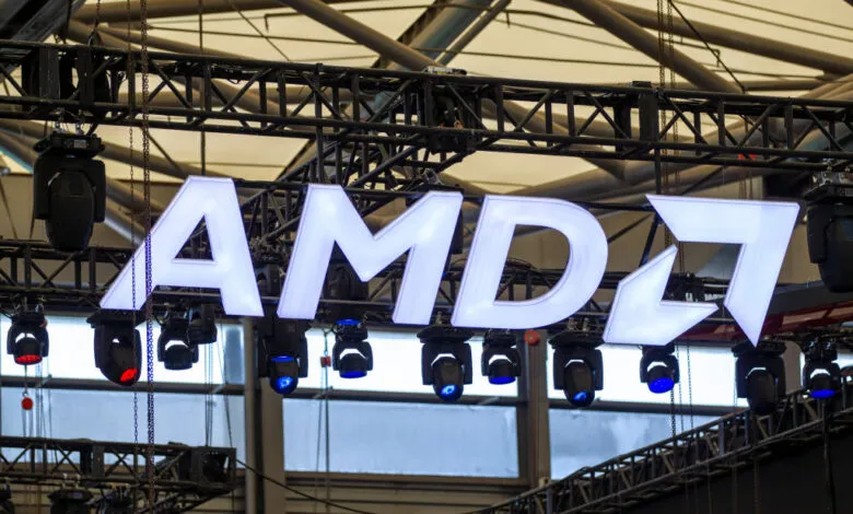 Large illuminated AMD logo with stage lighting and truss structures