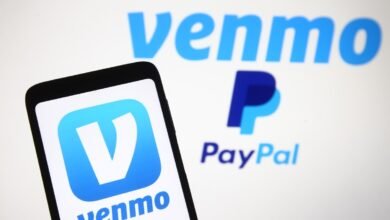 Smartphone displaying the Venmo app logo next to the blurred logos of Venmo and PayPal.