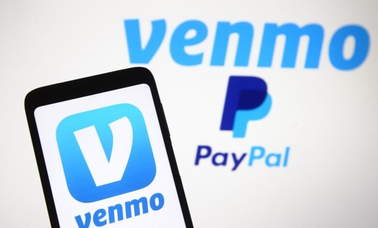 Smartphone displaying the Venmo app logo next to the blurred logos of Venmo and PayPal.