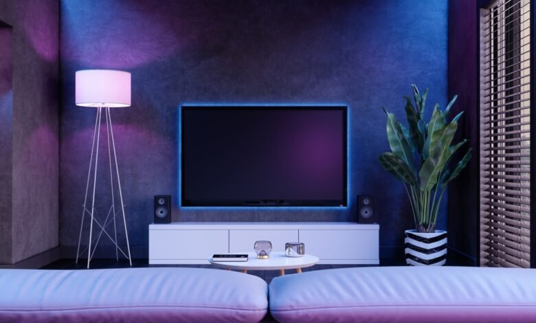 Modern living room with a large TV, ambient blue and purple lighting, and plush seating.
