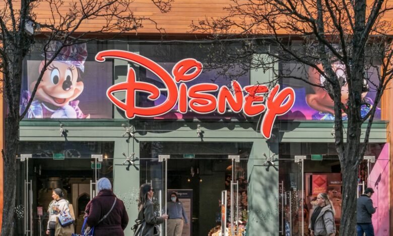 The iconic red Disney logo above the entrance of a store, with Minnie Mouse and Mickey Mouse characters displayed.