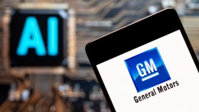Smartphone displaying the General Motors logo next to an AI symbol.
