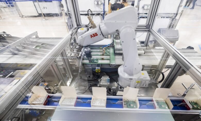 Automated robotic arm assembling electronic components on a conveyor belt in a factory.