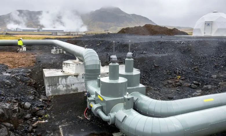 Geothermal power plant with large pipes and a geodesic dome structure.
