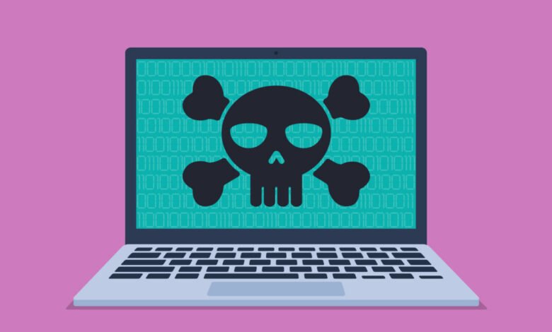 Laptop screen displaying a black skull and crossbones symbol over binary code.