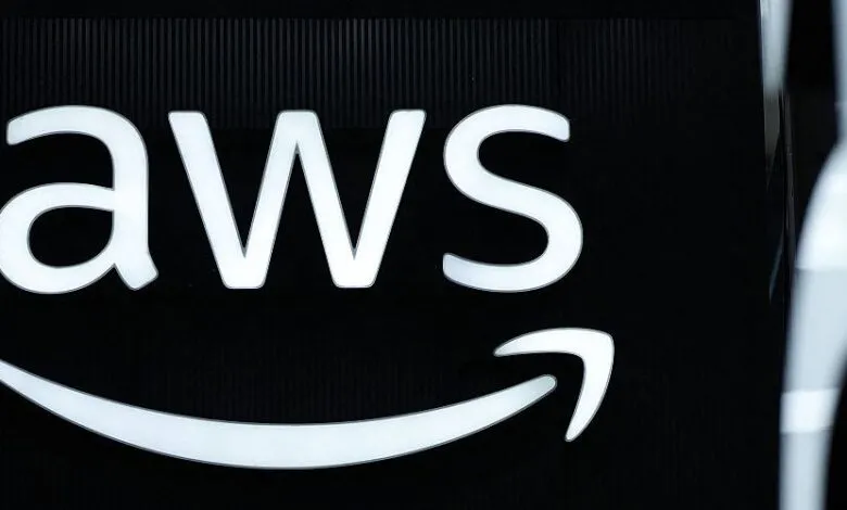 Close-up of the illuminated AWS logo on a black background.