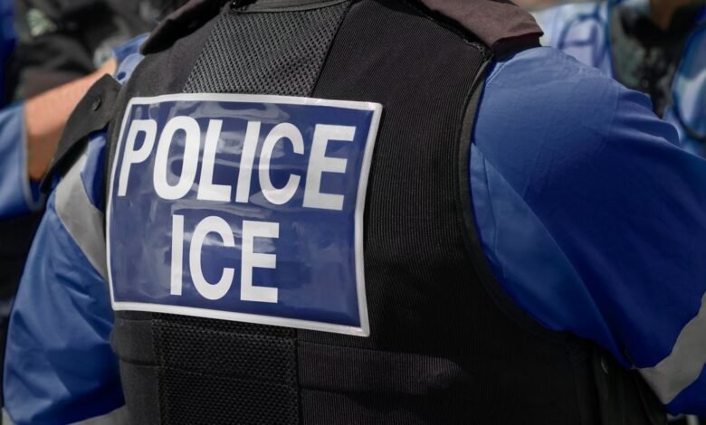 Close-up of a law enforcement officer's vest with 'POLICE ICE' clearly visible.