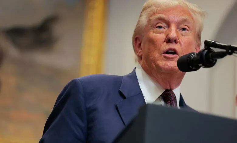 President Donald Trump speaking at a podium with a microphone in the White House.